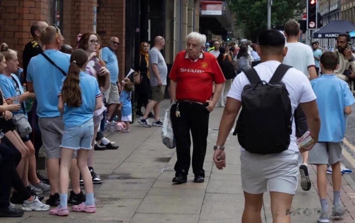 图评丨曼城夺冠大游行！图五：在曼彻斯特街道上一名身穿曼联球衣的球迷引起了摄影师的(5)